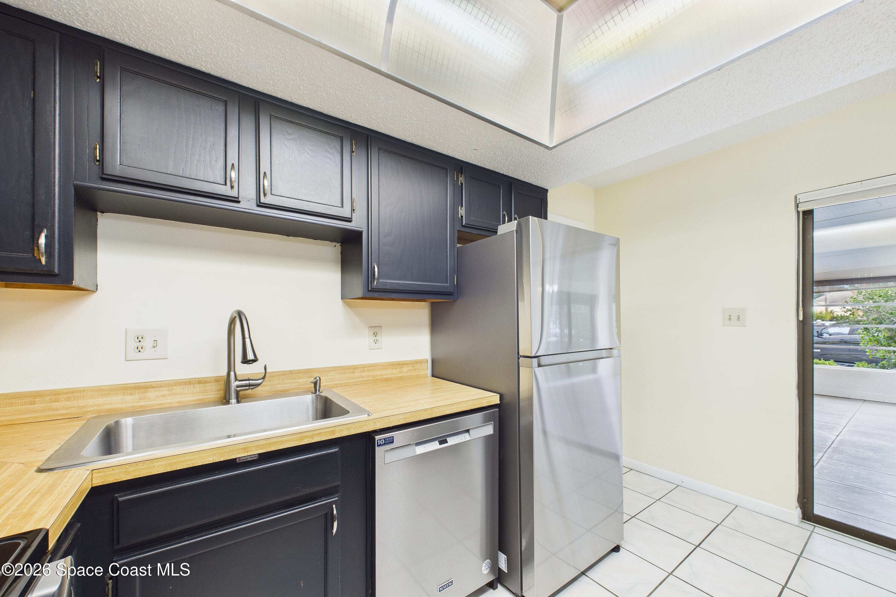 204 Country Club Drive Melbourne, FL 32940 - Photo 7 of 63 a kitchen with stainless steel appliances a refrigerator a sink and cabinets