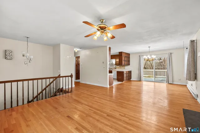 a view of an empty room with window and wooden floor