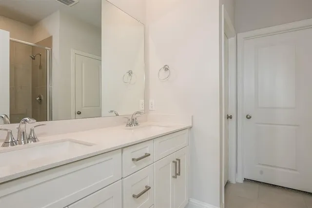 a bathroom with a granite countertop sink a mirror and a bathtub