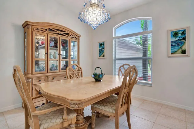 a dining room with furniture a large window and a chandelier