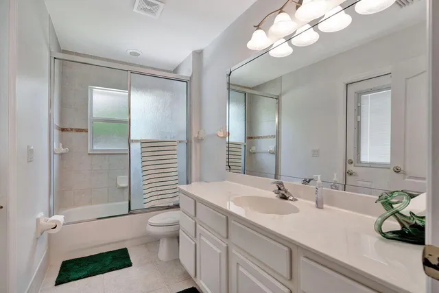 a bathroom with a sink a toilet and a large mirror