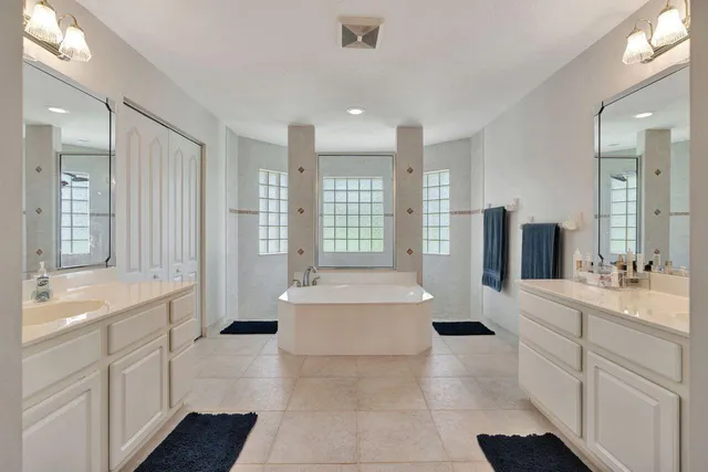 a bathroom with a tub sink and mirror
