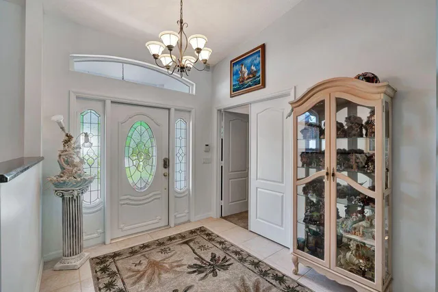 a view of a hallway with windows and chandelier