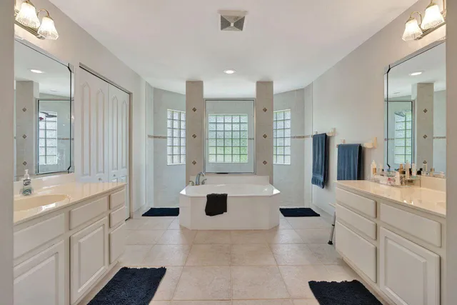 a bathroom with a tub sink and mirror