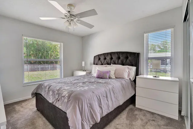 a bedroom with a large bed and a chandelier fan