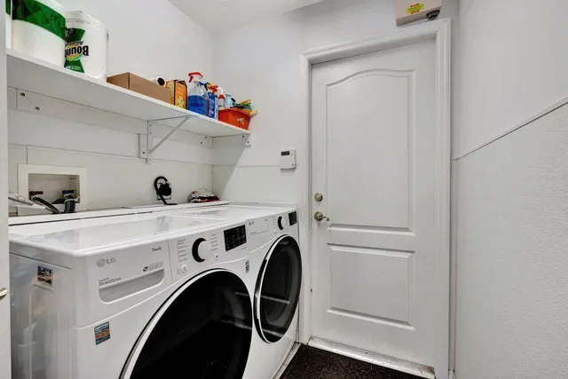 a view of washer and dryer with kitchen in the background
