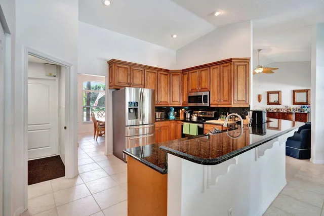 a kitchen with stainless steel appliances granite countertop a sink a refrigerator and a stove
