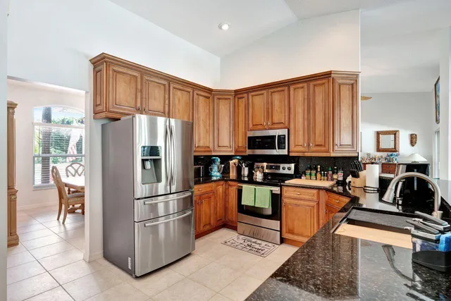 a kitchen with stainless steel appliances granite countertop a refrigerator and a stove top oven