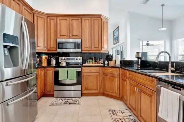 a kitchen with stainless steel appliances granite countertop a stove a sink and a refrigerator