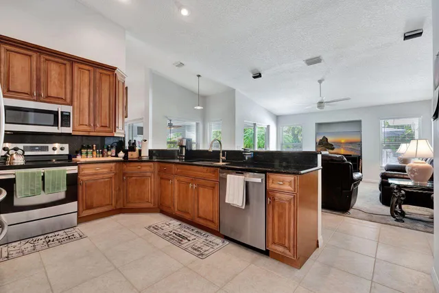 a large kitchen with stainless steel appliances granite countertop a stove and a sink