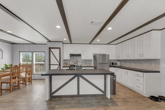 a kitchen with kitchen island granite countertop a sink window and cabinets