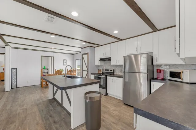 a kitchen with refrigerator a table and chairs