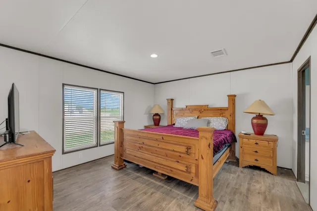 a bedroom with a bed and a tv on the dresser