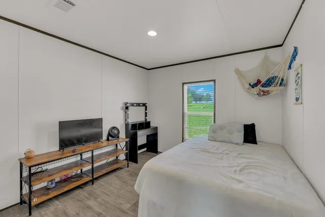 a bedroom with a bed and a flat screen tv