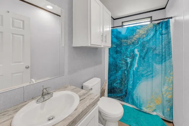 a bathroom with a sink toilet and shower