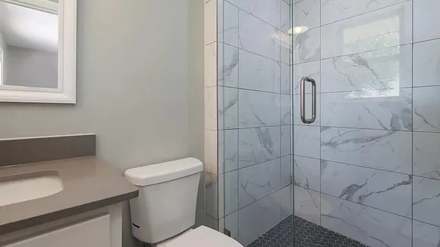 a white toilet sitting next to a bathroom sink