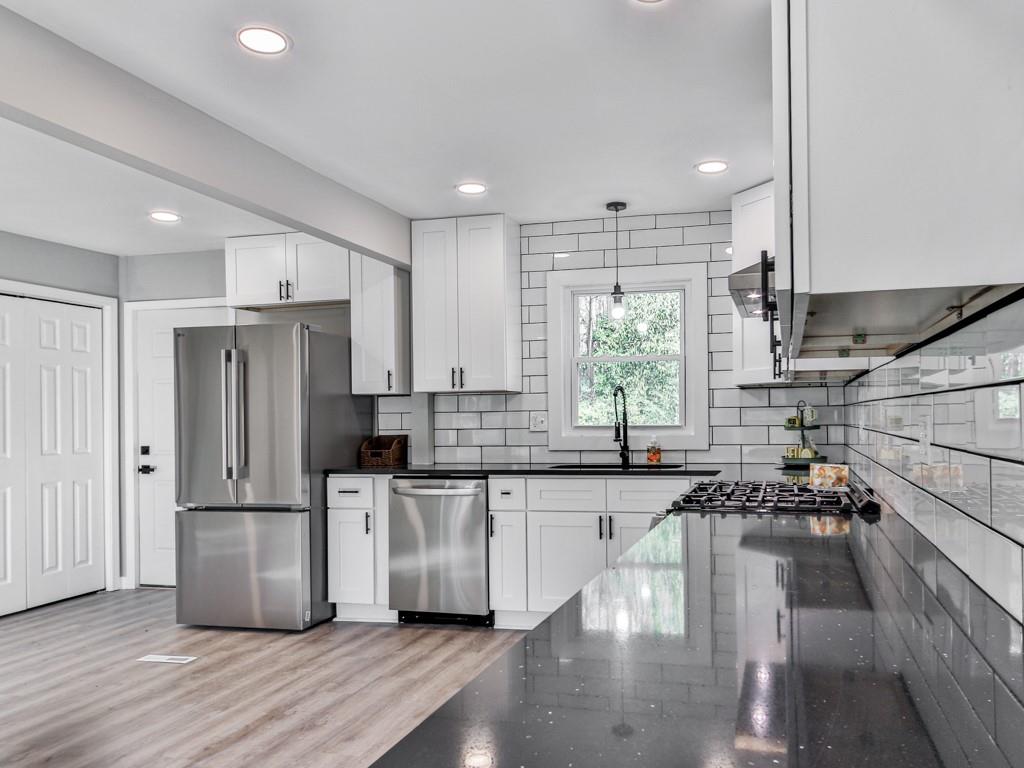 5205 Silhouette Lane Southwest Mableton, GA 30126 - Photo 11 of 21 a kitchen with stainless steel appliances granite countertop a refrigerator a sink dishwasher a stove and white countertops with wooden floor