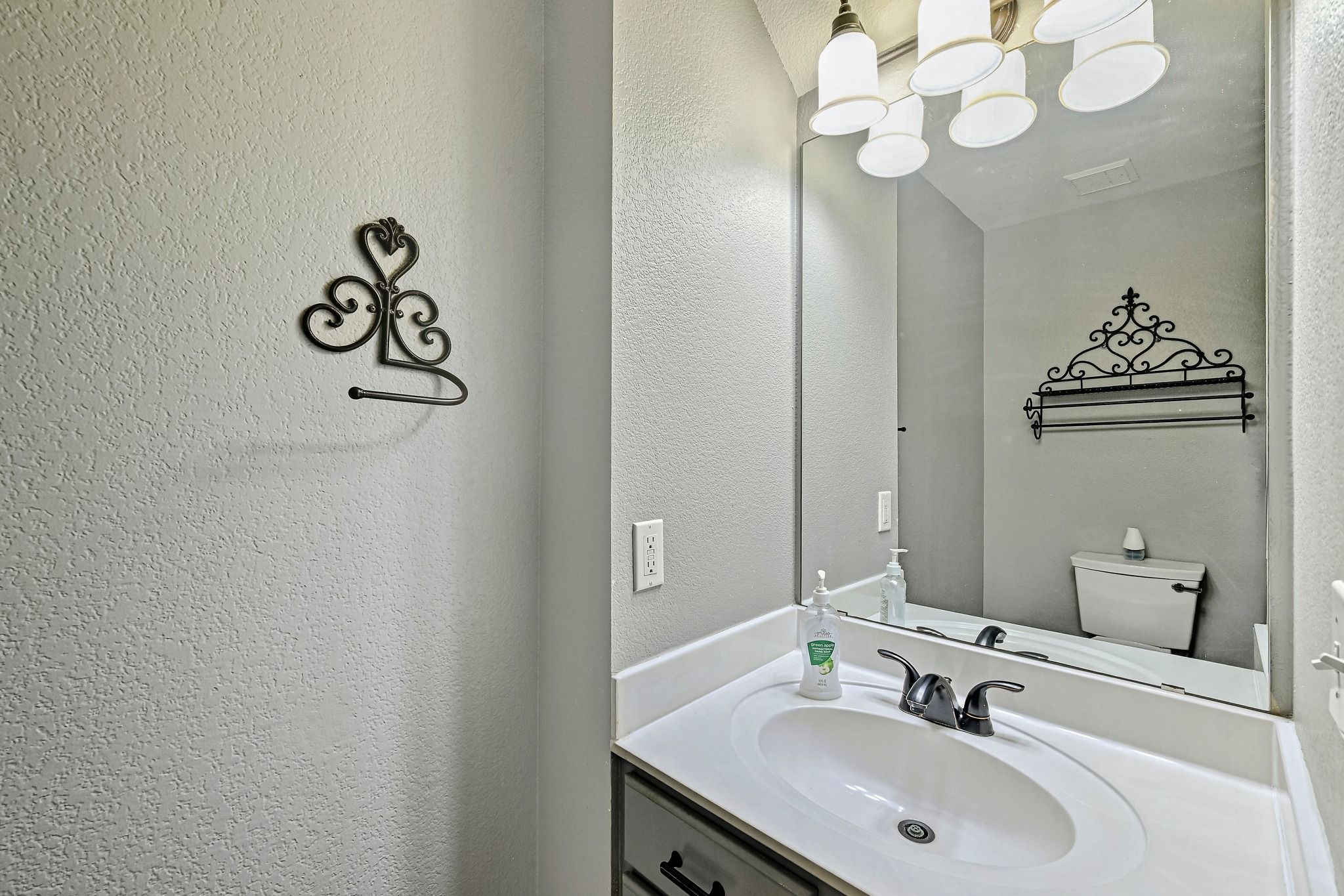 104 North Sumac Lane Georgetown, TX 78633 - Photo 24 of 40 A well-lit bathroom vanity with a clean white sink and practical mirror.