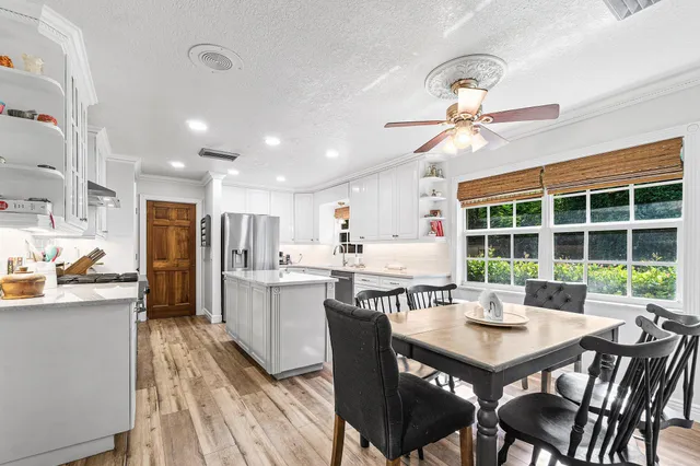 a kitchen with a dining table chairs and refrigerator