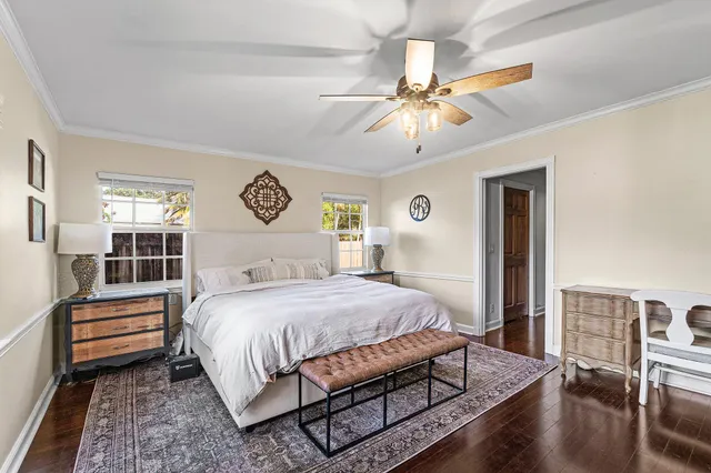 a bedroom with a bed chandelier and a window