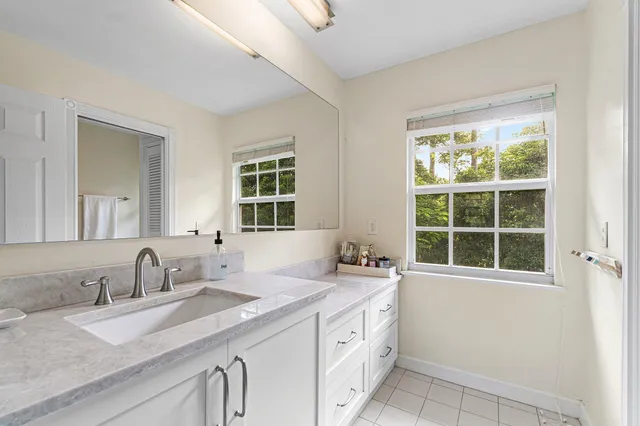 a bathroom with a granite countertop sink and a window