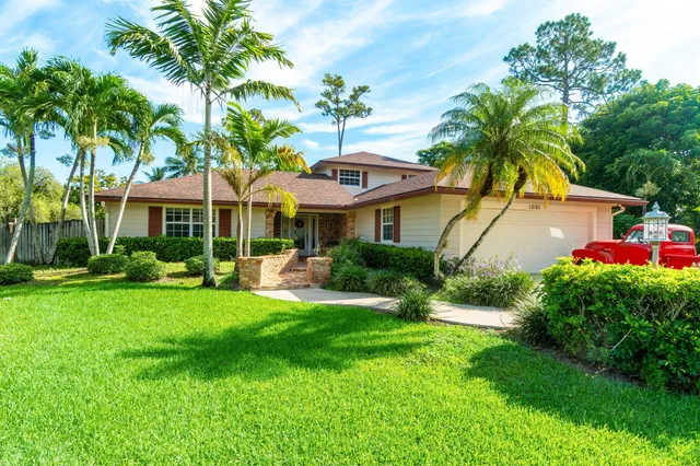 a view of a house with a yard and potted plants