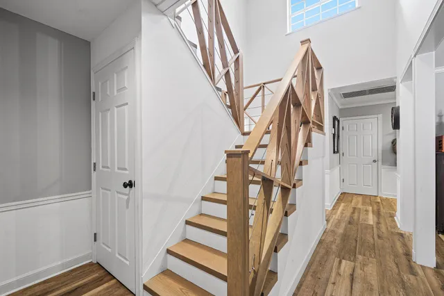a view of a hallway with wooden floor and staircase
