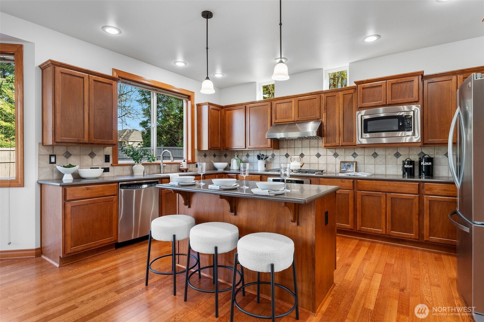 202 Chelan Court Northeast Renton, WA 98059 - Photo 8 of 40 a kitchen with stainless steel appliances granite countertop a stove a sink a microwave a center island and a cabinets