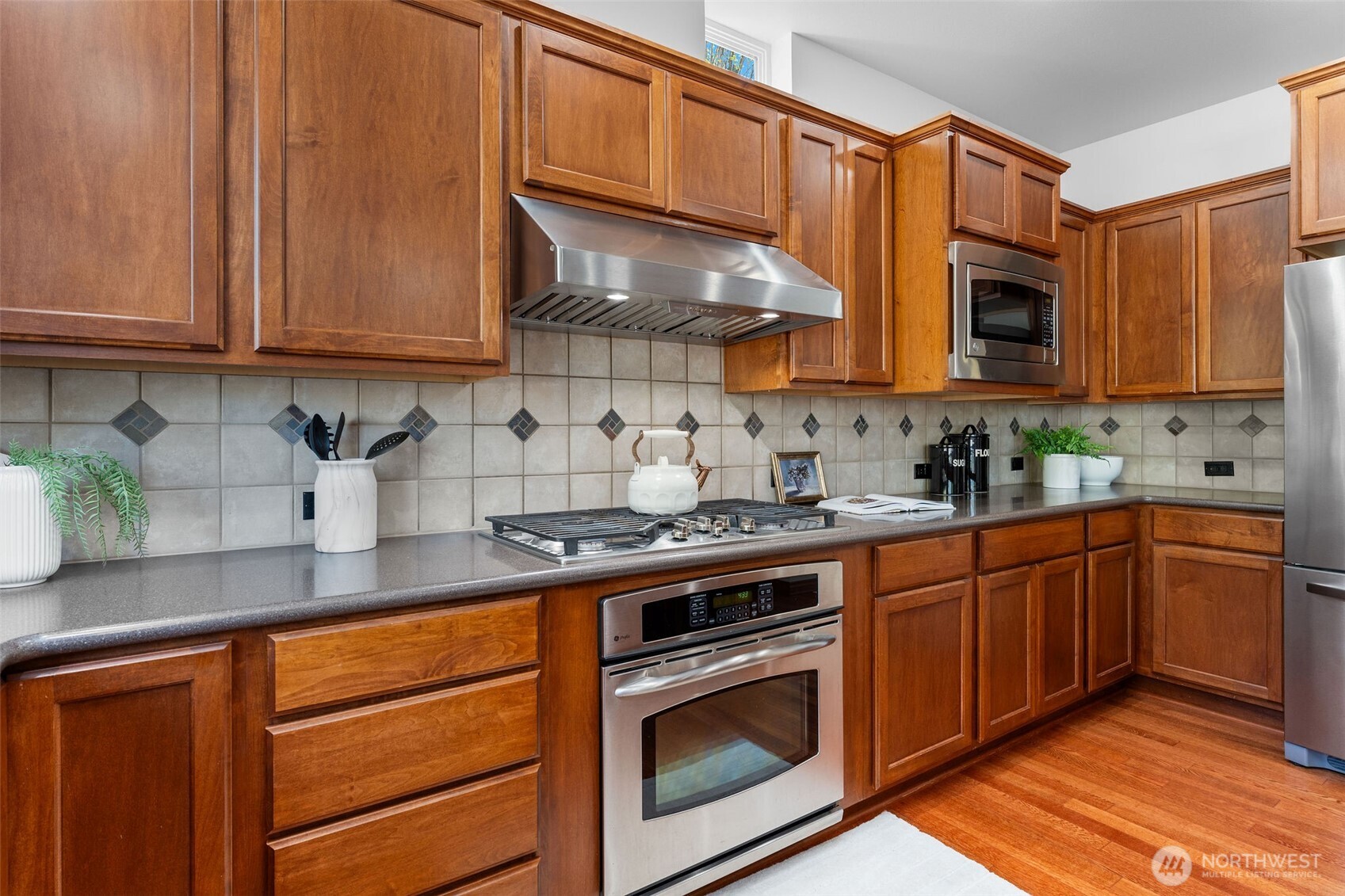202 Chelan Court Northeast Renton, WA 98059 - Photo 9 of 40 a kitchen with stainless steel appliances granite countertop wooden cabinets a stove a sink and dishwasher