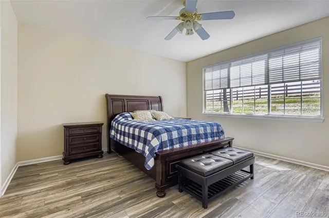 a bedroom with a bed and a dresser with wooden floor