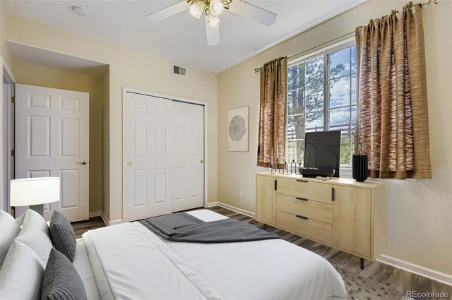 a bedroom with a bed and a flat tv screen on dresser
