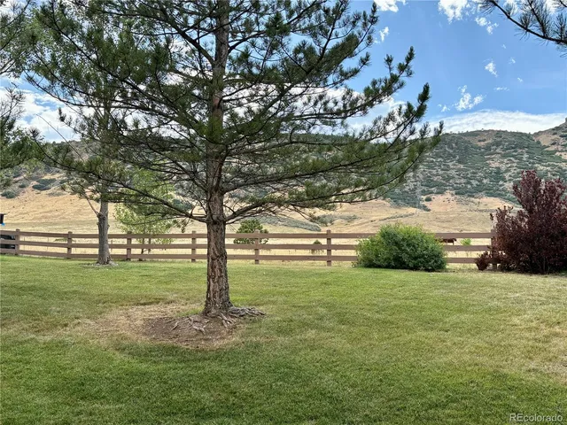a view of a fountain in front of a house with a big yard