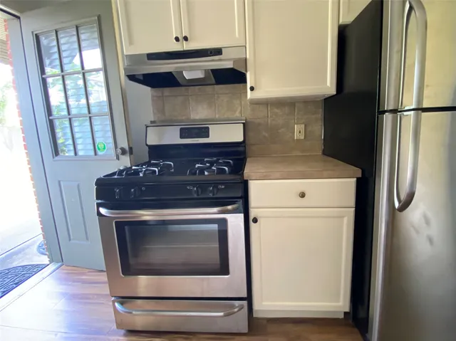 a stove top oven sitting inside of a kitchen