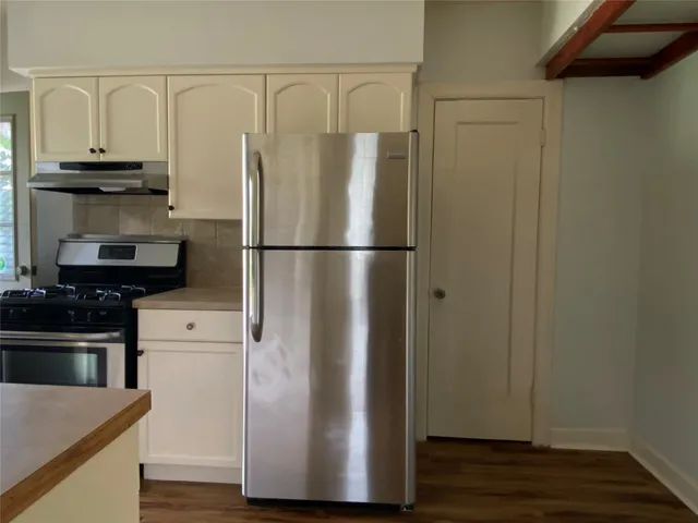 a white refrigerator freezer and a stove sitting inside of a kitchen