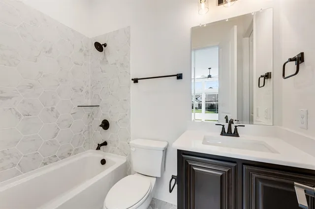 a bathroom with a sink a toilet a mirror a bathtub and shower