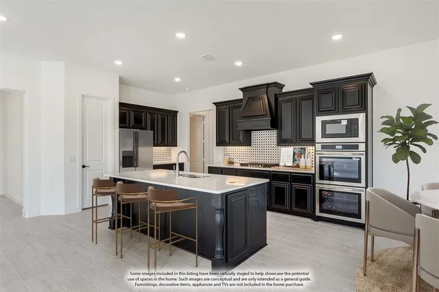 a kitchen with stainless steel appliances kitchen island granite countertop a stove refrigerator and microwave