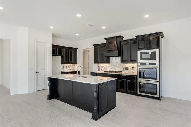 a kitchen with stainless steel appliances granite countertop a sink and a stove
