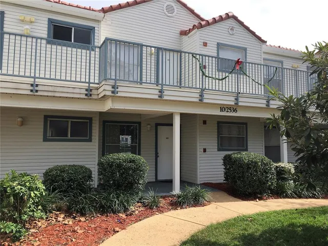 a view of a house with brick walls and a small yard