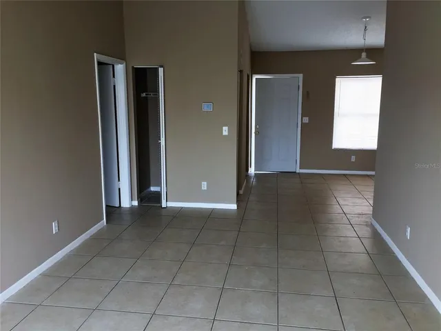 an empty room with windows and closet