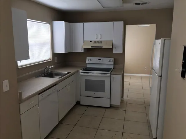 a kitchen with a stove a refrigerator and a sink