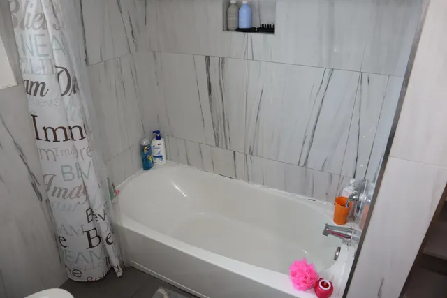 a bedroom with a bed and a flat tv screen on a dresser