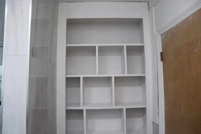 a bedroom with a bed and a flat tv screen on dresser