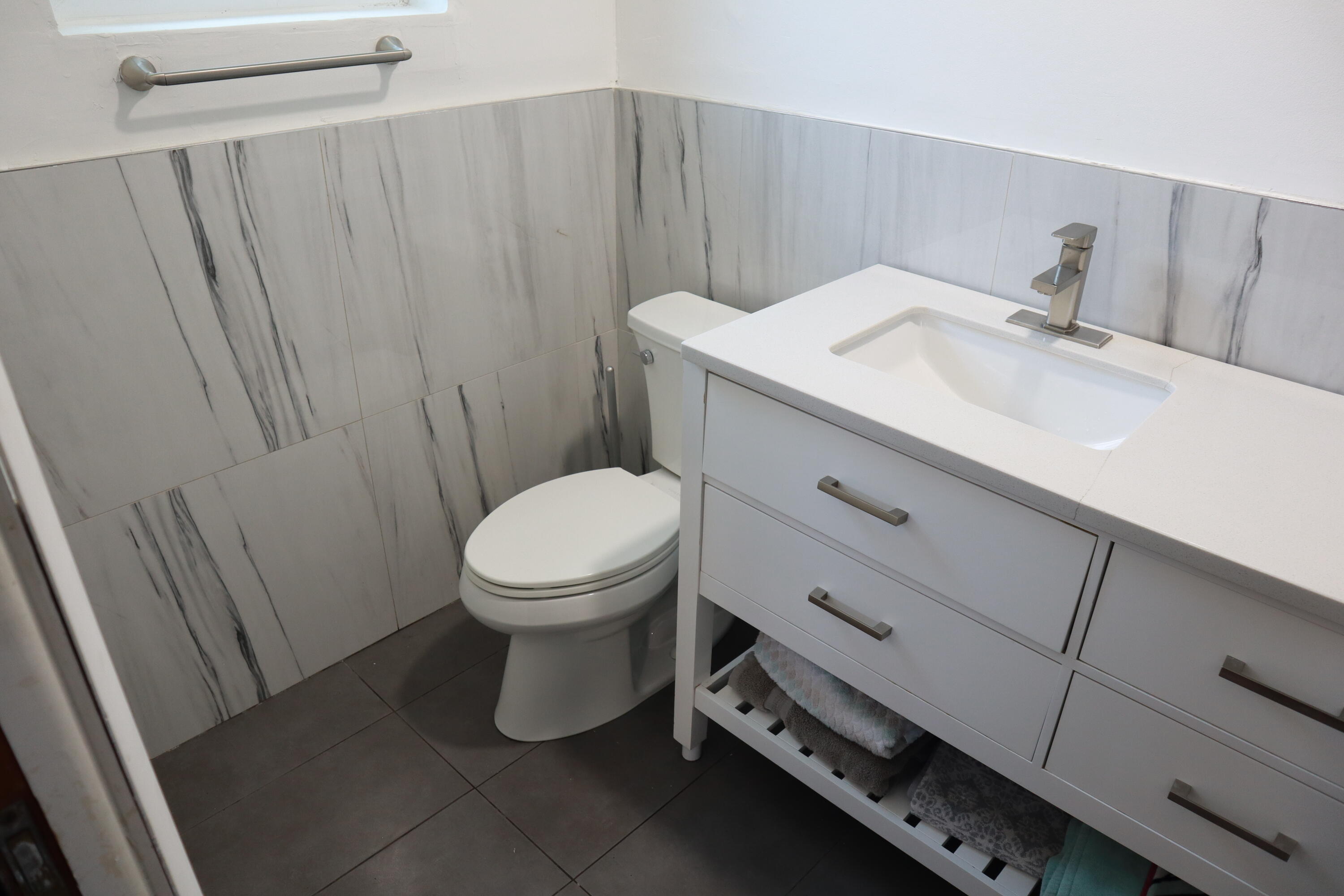 360 Kismet Avenue Pahokee, FL 33476 - Photo 41 of 100 a bathroom with a sink a toilet and a mirror