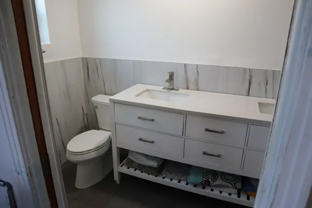 a view of a backyard with wooden fence and a large tree