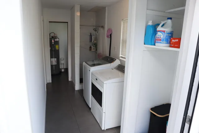 a bedroom with a bed next to a window with the kitchen view