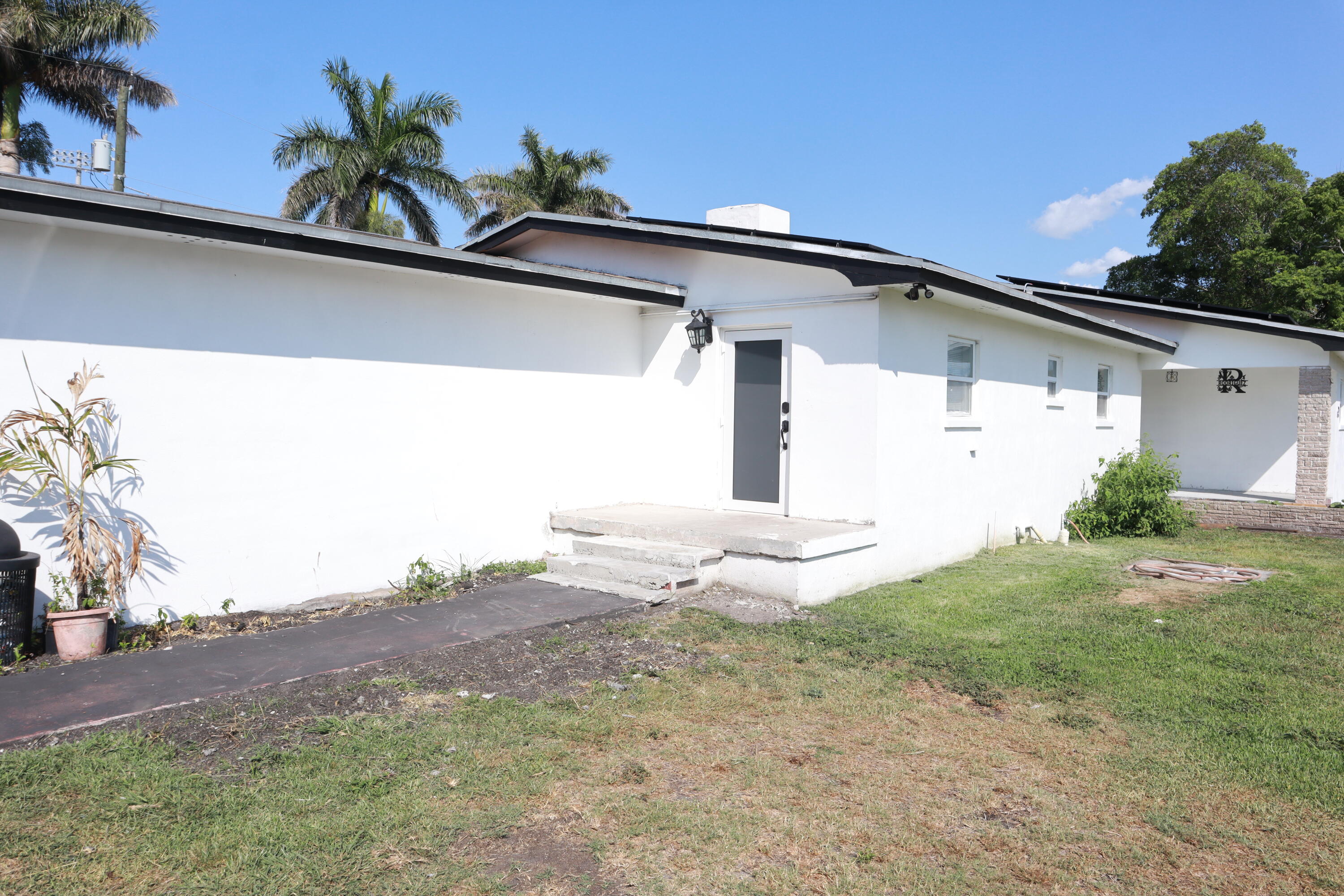 360 Kismet Avenue Pahokee, FL 33476 - Photo 70 of 100 a front view of a house with a yard and garage