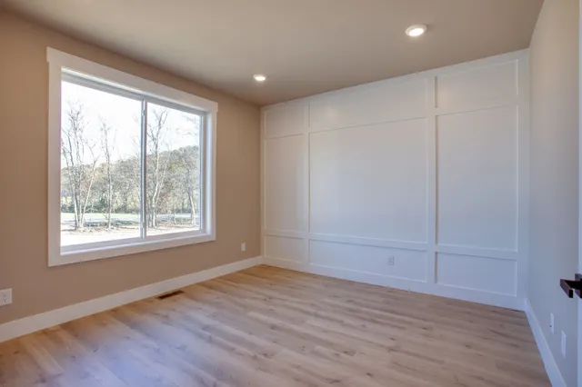 an empty room with wooden floor and sliding door