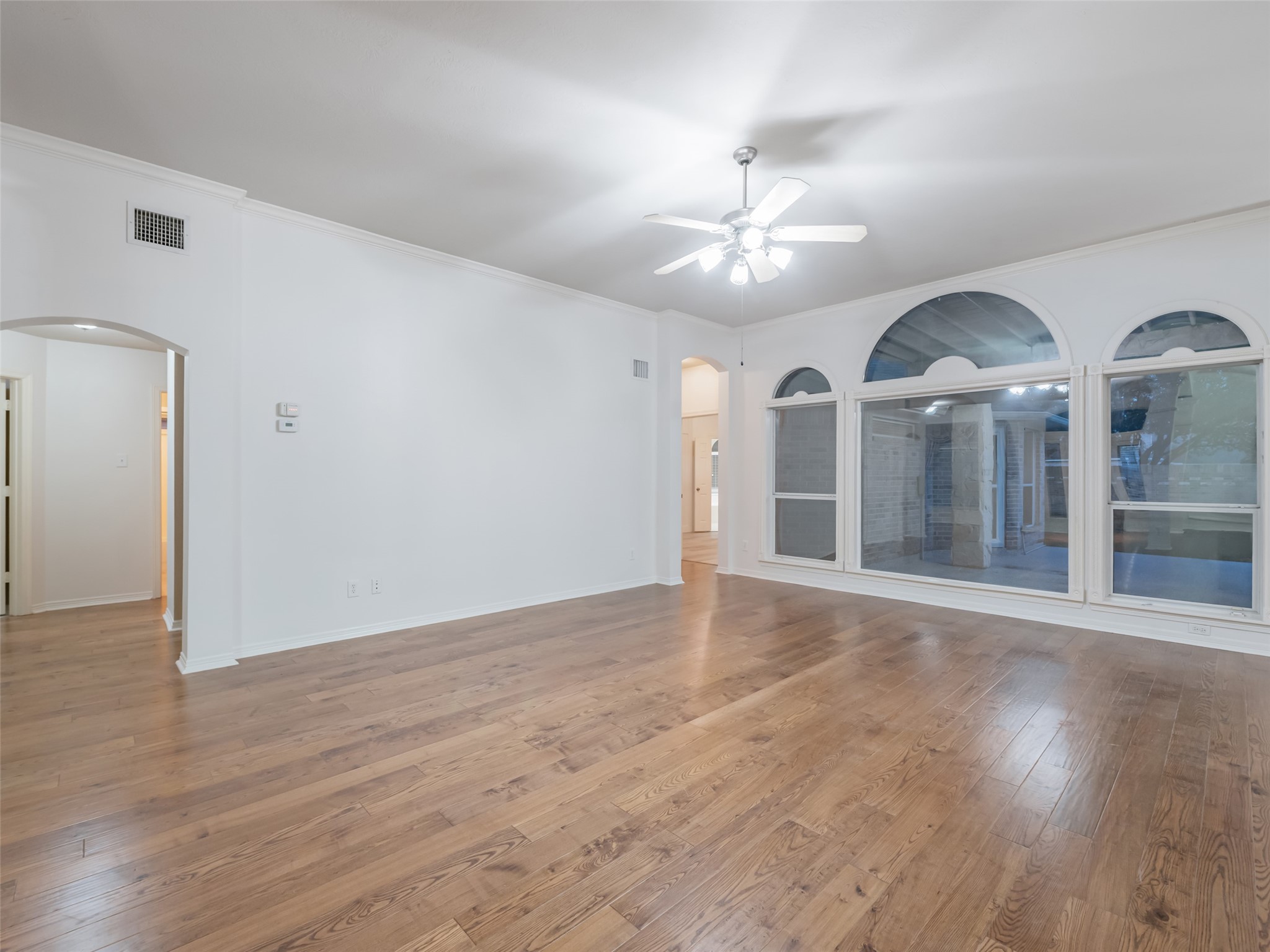 1511 Baldridge Lane Katy, TX 77494 - Photo 12 of 50 a view of an empty room with wooden floor and a ceiling fan