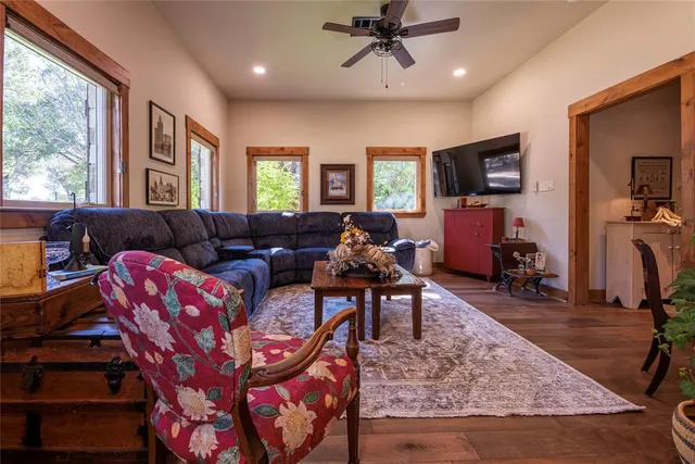 a living room with furniture a flat screen tv and a large window