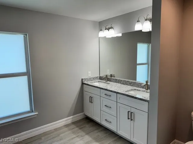 a bathroom with a granite countertop sink and a mirror